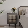 Dark Rattan Panel Bedside Table With Vase Flowers And Cup In Bedroom