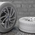 Stacked Car Tires And Tire With Volkswagen Wheel Rim On Brick Wall Background