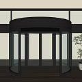 Modern Revolving Door Design With Glass Panels Black Frame Wooden Floor And Green Plant