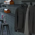 Gray Wall Retail Display With Hanging Shirts Orange Boxes And Stools