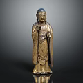 Golden Standing Buddha Statue With Robed Figure And Raised Hand Gesture In Traditional Decorative Design