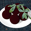Fresh Black Fruits Arranged On White Plate With Green Leaves On Dark Patterned Tablecloth