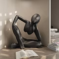 Black Abstract Human Figure Sculpture in Sitting Posture with Open Book and Stacked Books Indoor