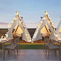 Outdoor Restaurant With White Tents String Lights Tables Chairs Green Plants Pebble Ground Evening