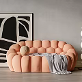 Peach Button tufted Sectional Sofa With Gray Blanket Decorative Ball And Black White Abstract Painting