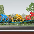 Colorful Blue Yellow Red Bicycle Sculptures Near Track With Trees And Person Cycling
