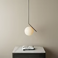 Elegant Spherical Pendant Light With Metal Frame Over Marble Countertop And Books