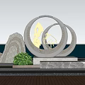 Outdoor Metal Sculpture With Interlaced Circular Rings Coastal Waterfront Rocks And Green Plants