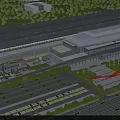 Modern Railway Station With Large Roof Structure Surrounding Greenery Parking Lots And Roads