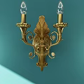 Elegant Golden Double Arm Wall Lamp With Ornate Design On Teal Wall