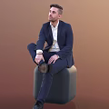 A Man In Navy Suit White Shirt Sitting On Gray Cylindrical Stool Brown Background