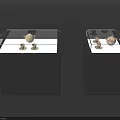 Black Display Cabinets With Glass Tops Showcasing White And Gold Decorative Items