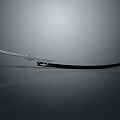 Ornate Decorative Sword With Black Blade And Metallic Hilt On Gray Reflective Surface