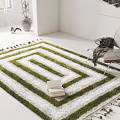 Square Green And White Geometric Carpet With Tassels In White Room With Chair And Books