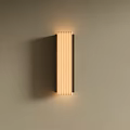 Long Striped Modern Wall Sconce With Warm Lighting Mounted On Beige Wall