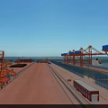 Spacious Industrial Plant Area With Red Cranes Blue Sky Water View And Rail Tracks