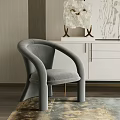 Gray Curved Armrest Accent Chair In Modern Interior With Cabinet And Decorative Objects