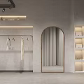 Minimalist Clothing Store Interior with Hanging Clothes Arched Mirror and Shelved Cabinets