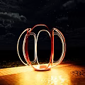 Outdoor Sculptural Art Installation With Red Orange Circular Rings Against Blue Sky