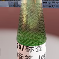 Transparent Green Glass Beverage Bottle with Label and Logo on Light Background