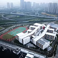 Modern School Building Complex With Red Track Sports Field And Urban Surroundings