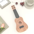 Wooden Ukulele and Art Supplies Displayed on White Table with Decorative Items