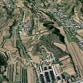 Aerial View Of Rural Mountainous Landscape With River Road And Farmland