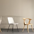 Four Different Designed Dining Chairs Arranged Against Light Colored Wall With Gray Floor