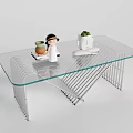 Modern Glass Top Coffee Table With Metal Frame And Small Decor Items And Potted Plant