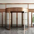 Brass Frame Revolving Door With Glass Panels And Green Plant On Polished Marble Floor