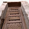 Traditional Building Exterior Wall with Intricate Carved Wooden Door and Rough Texture