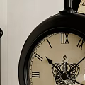 Two Black Decorative Clocks With Roman Numerals On Light Colored Wall