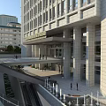 Modern Hospital Building Exterior With Stone Facade Main Entrance Columns And Pedestrian Plaza