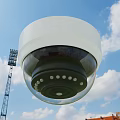 Outdoor Dome Surveillance Camera Against Blue Sky White Clouds Light Tower And Buildings