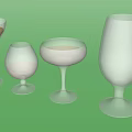 Various Shaped Stemmed Wine Glasses Filled With Different Colored Liquids On White Background