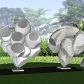 Stainless Steel Geometric Landscape Sculpture In Lawn Garden With Greenery And Trees