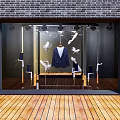 Storefront Glass Window Display with Brick Wall Blue Suit Mannequins and White Bird Decorations
