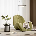 Green Lounge Chair with Quilted Texture Throw Blanket Side Table Plants and Pendant Light
