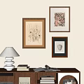 Abstract Paintings on Wall with Brown Frames in Interior with Bookshelf Lamp and Open Book