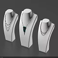 Elegant Jewelry Necklaces On White Display Stands With Layered Chains And Green Pendant