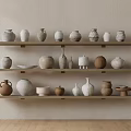 Display of Various Ceramic Vessels on Wooden Shelves Against Beige Wall with Wooden Floor