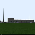 Industrial Factory Building With Gray Exterior Multiple Windows Doorways Green Grass Field And Tall Tower