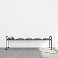Modern Black Metal Shelf with Circular Trays Against White Wall and Gray Carpet