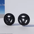 Two Black Circular Stove Components Against White Wall And Blue Sky
