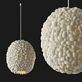 Two White Spherical Textured Chandeliers Glowing Against Black Background In Modern Interior