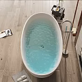 White Oval Bathtub with Light Blue Water on Wooden Floor and Slippers on Gray Mat