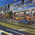 Vibrant Commercial Street at Dusk with Illuminated Modern Buildings Shops Pedestrians and Moving Cars