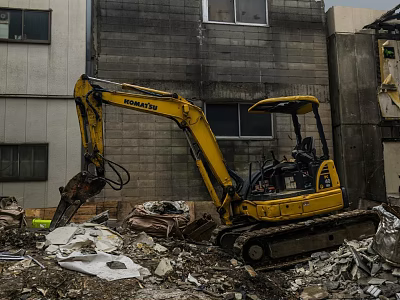 KOMATSU Yellow Excavator Engaged In Demolition Work Amidst Rubble And Old Buildings 3d model