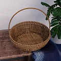 Woven Rattan Basket On Wooden Table With Green Plant And Blue Cloth