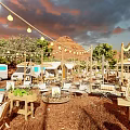 Scenic Outdoor Campsite With White Tents Dining Tables And Umbrellas Surrounded By Trees